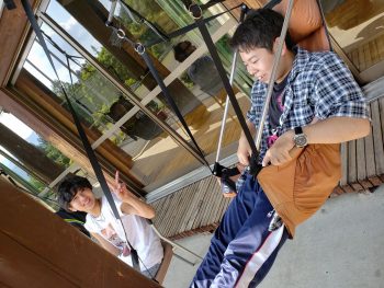 画像１２さる小の多目的ホールの軒下のハンモックから観戦